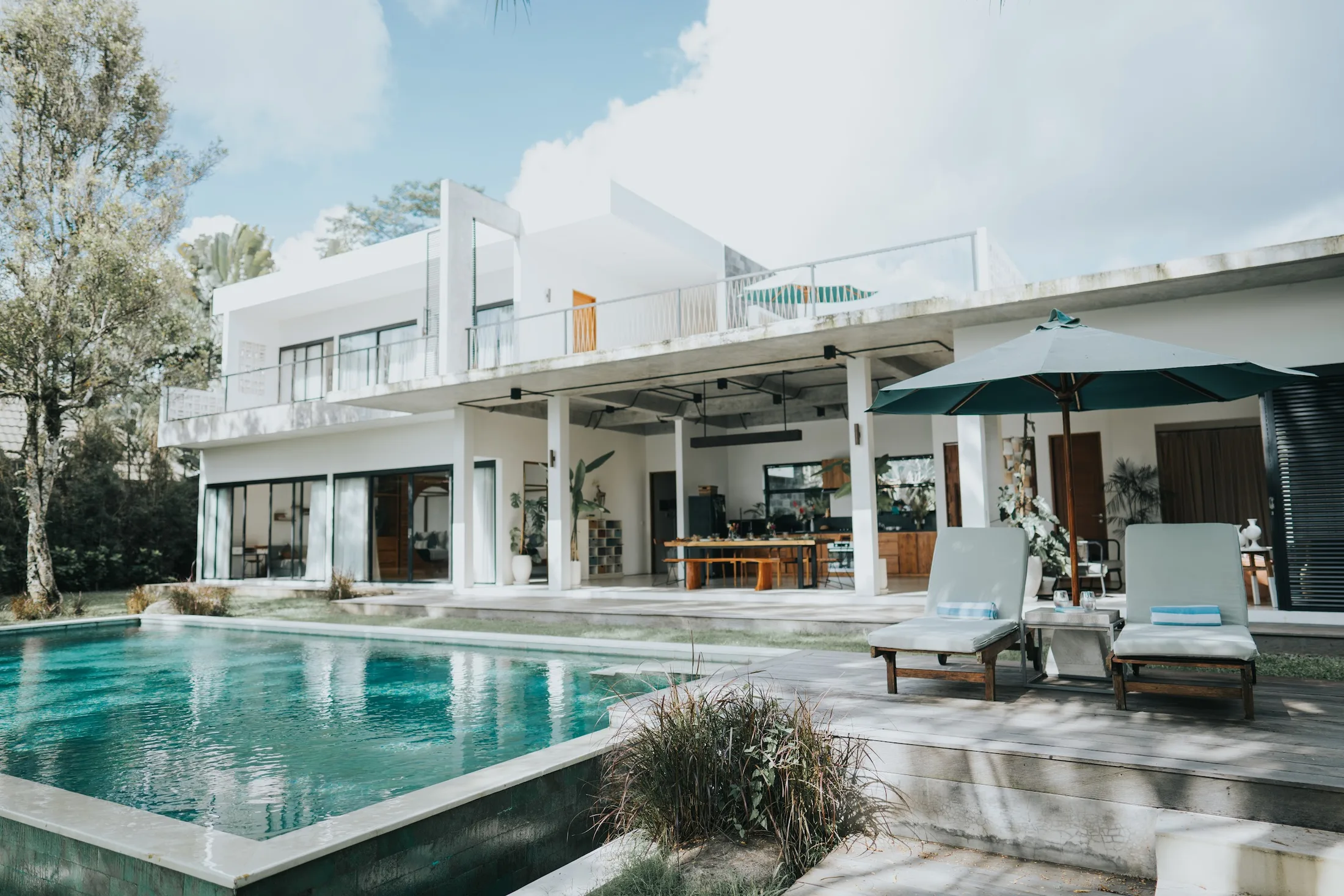 Long swimming pool surrounded by trees and garden